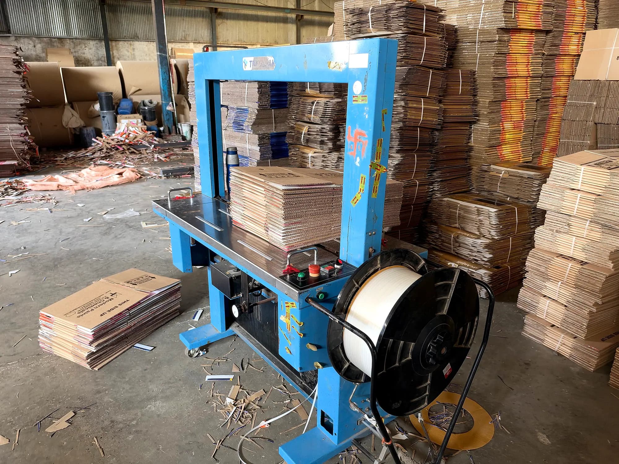Strapping machine bundling finished corrugated boxes for dispatch at FIDVI Industries