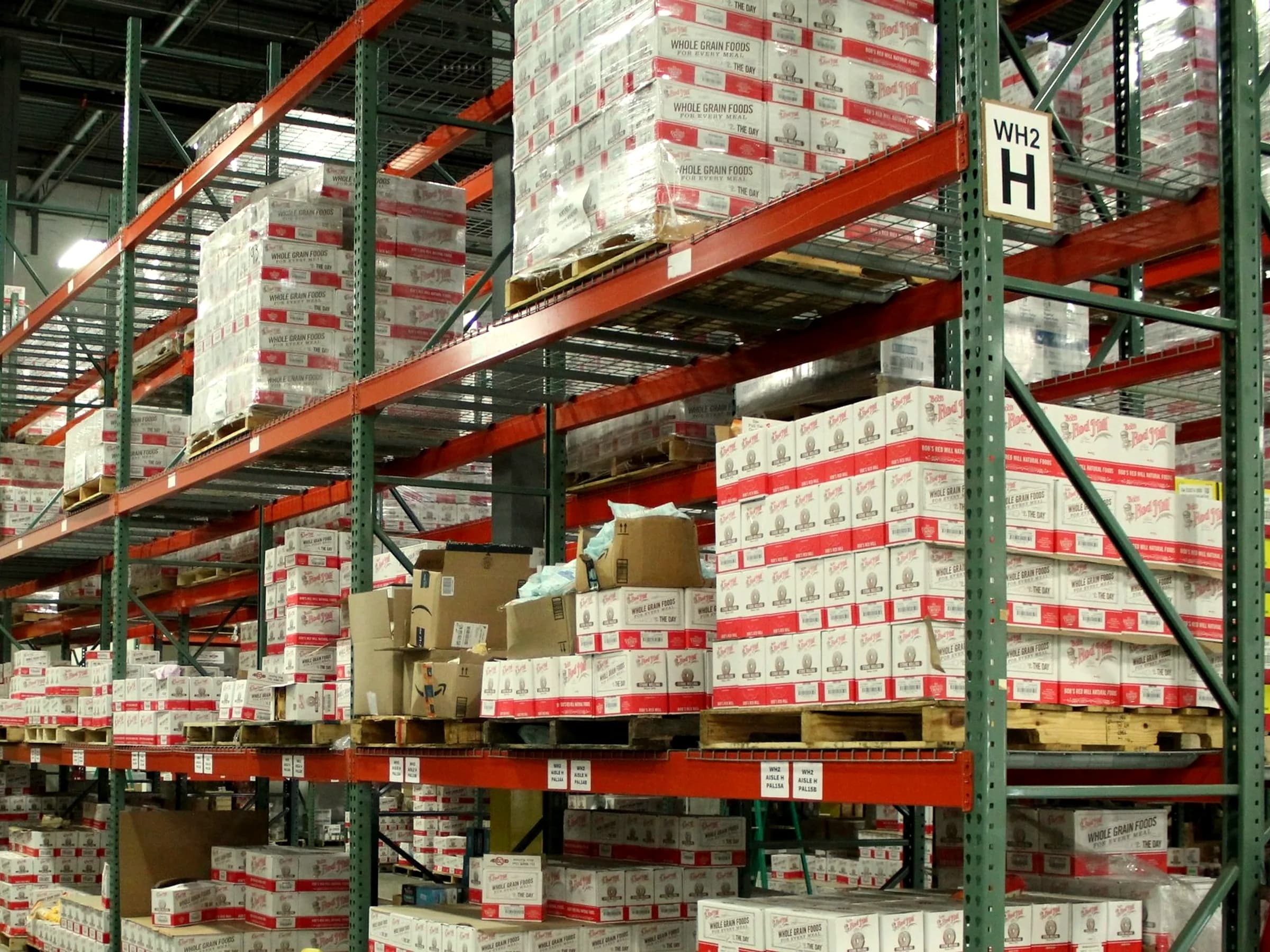 White and coloured cartons stacked on warehouse shelving